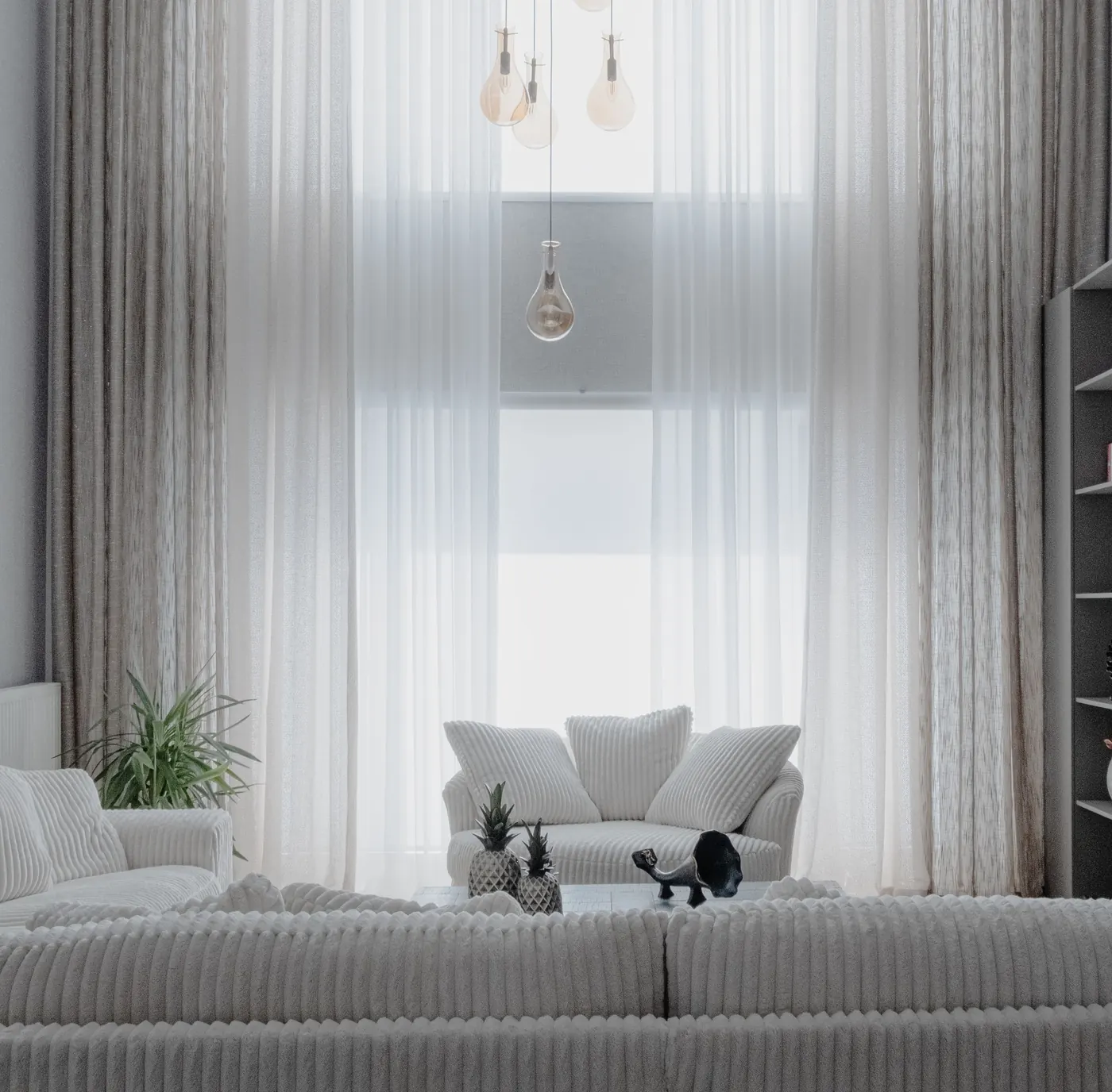 The finished living room: a wall of tall windows with sheer white curtains, white sofas, two armchairs and glass pendant lights.