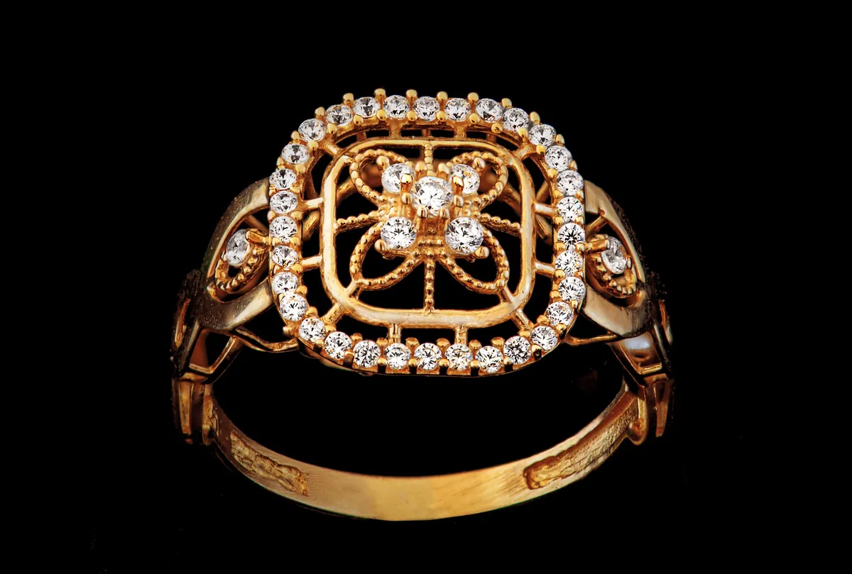 A wide rose gold cocktail ring with diamond filigree.