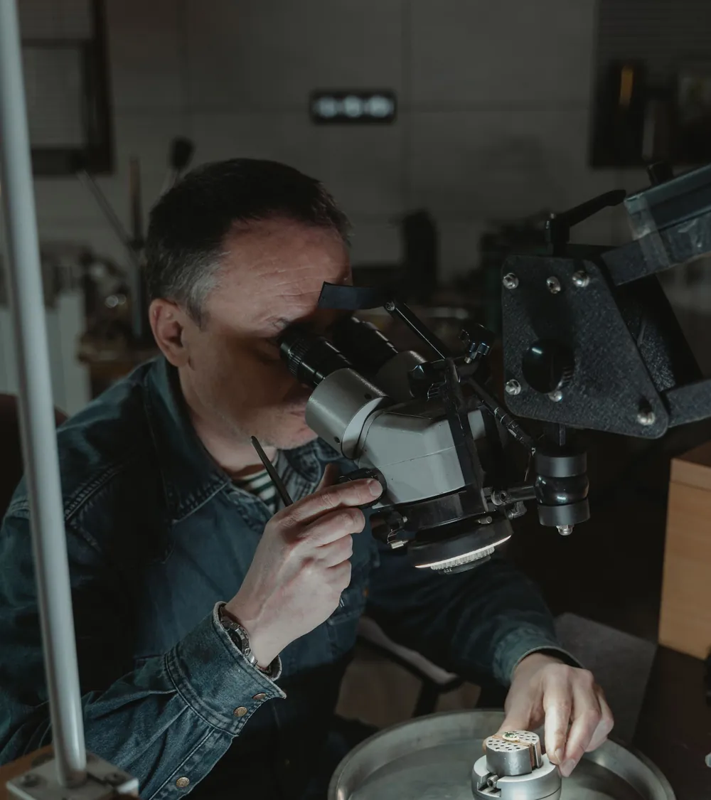 A jeweller setting a stone under a microscope.