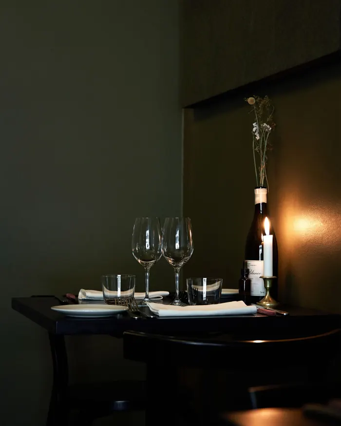 A table set for two with wine glasses and a single candle.